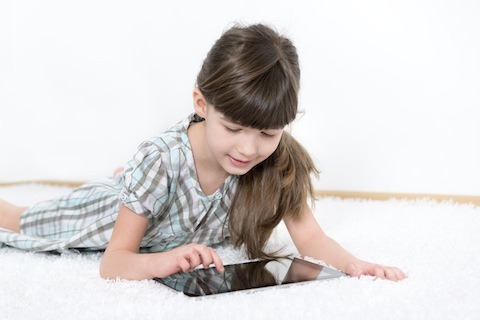 stock photo 23514521 klein meisje speelt met een tablet