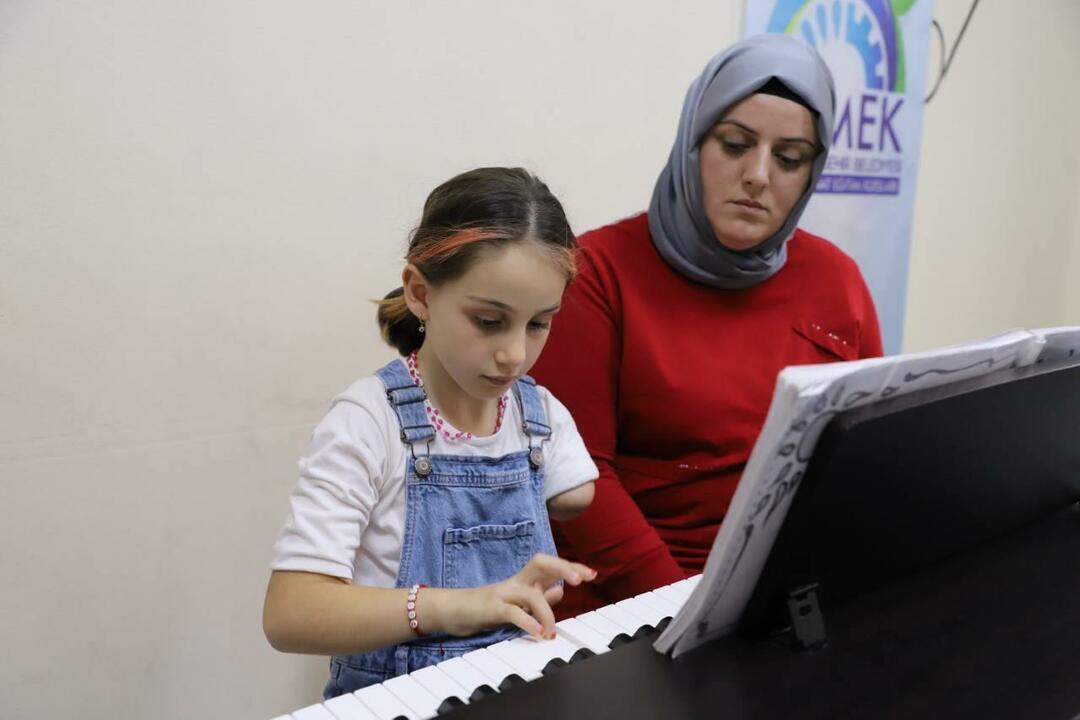 Zeynep, die niet met een linkerarm is geboren, wordt ondersteund door haar moeder.