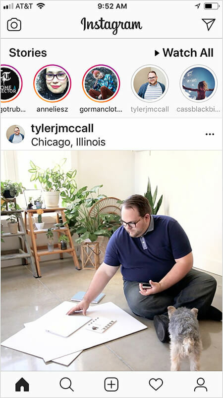 Tegen Tyler J. McCall heeft gemerkt dat het Instagram-algoritme meer van de inhoud van een account in de feed lijkt te laten zien als je het Instagram-verhaal van het account bekijkt of ermee communiceert, en vice versa. Het startscherm van een gebruiker op Instagram toont een bericht van Tyler nadat de gebruiker zijn verhaal heeft bekeken. De Instagram-feedafbeelding toont Tyler zittend op de grond met grote vellen wit papier en een notitieboekje. Een kleine zwartbruine hond staat Tyler onder ogen. Op de achtergrond staan ​​veel groene planten op ladders.
