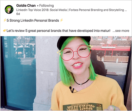 Dit is een screenshot van Goldie Chan die een video deelt met een duidelijke afhaalmaaltijd. De tekst boven de video zegt: "5 sterke persoonlijke LinkedIn-merken Laten we eens kijken naar 5 geweldige persoonlijke merken die zich hebben ontwikkeld tot volwassen.. Bekijk meer". In het videobeeld verschijnt Goldie vanaf de borst omhoog. Ze is een Aziatische vrouw met groen haar. Ze draagt ​​make-up, een zwarte halsketting en een geel overhemd. Een videofilter zorgt ervoor dat het lijkt alsof ze een rode bril draagt ​​die is geschetst met een stift.
